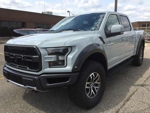 silver ford f 150 in a concrete parking lot