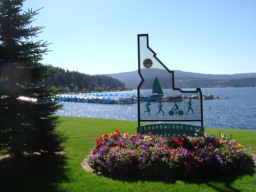 metal sign in the shape of Idaho with lake Coeur d'Alene in the background