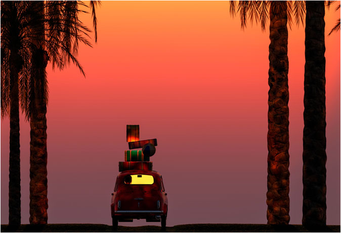 Car with luggage on top driving towards sunset
