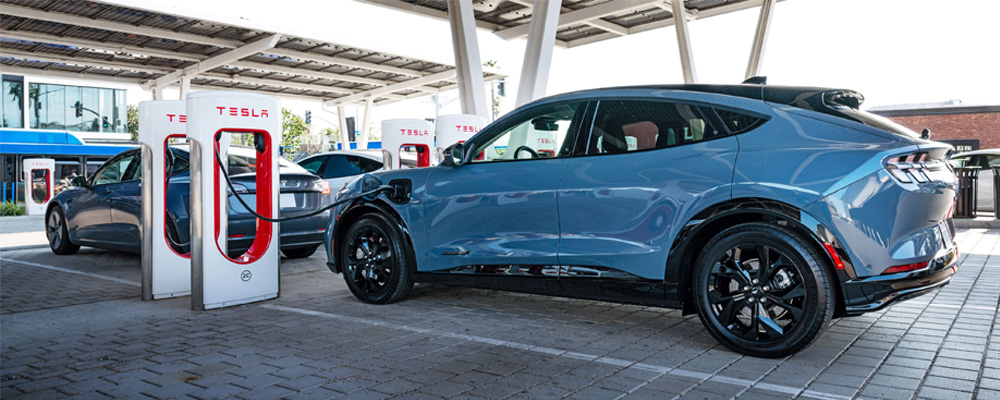 A blue car plugged in at an electric charging station