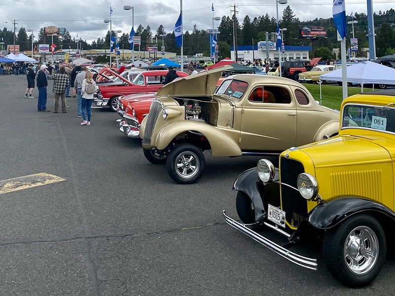 A row of classic cars and trucks.