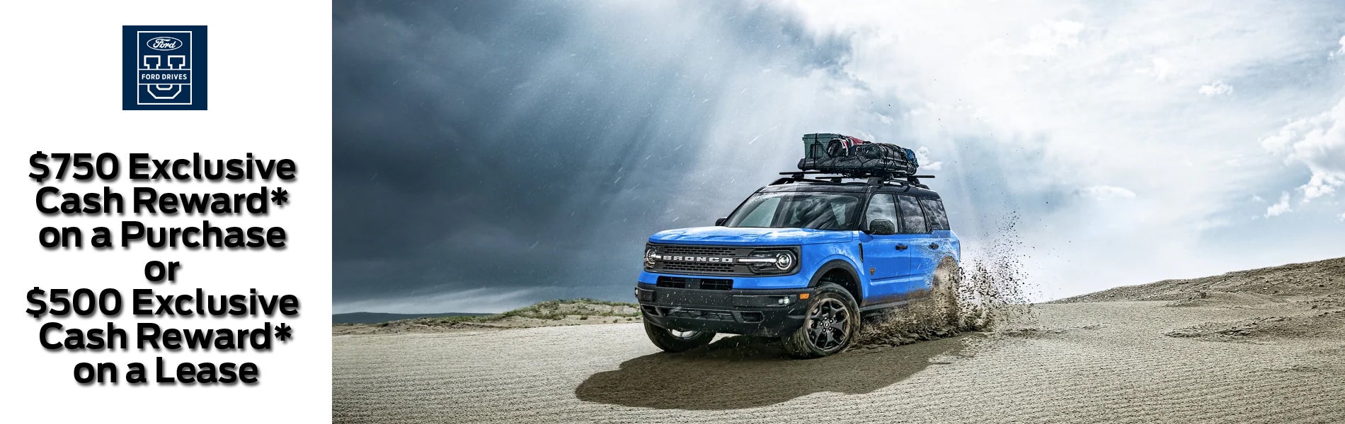 A blue Ford Bronco Sport driving on sand dunes with sun rays coming through a cloudy sky.